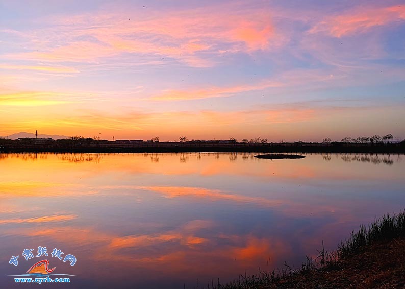 夕阳余晖映霞光，天际染红展辉辉